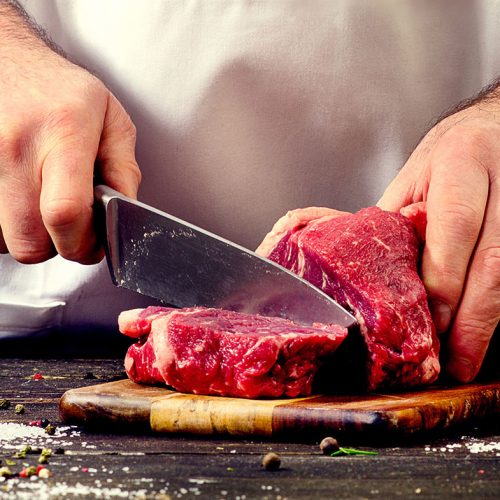 Man cutting beef meat.