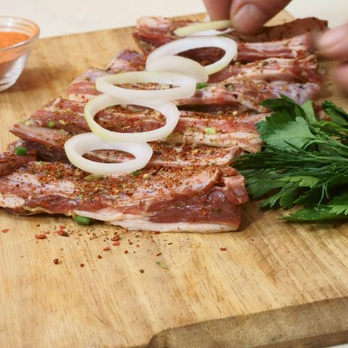 hands preparing meat for barbecue